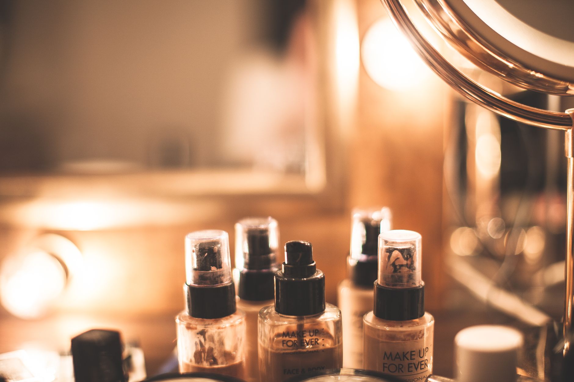 A stylish setup showcasing foundation and makeup products on a vanity table.